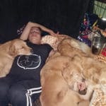 Golden Retrievers and owner laying down together on floor at TNT, Midland, MI