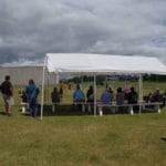Oblong shade canopy with benches underneath and spectators watching agility trial iin St Cloud MN