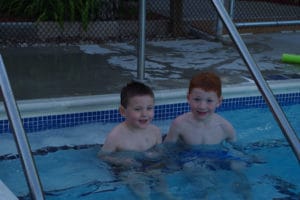 Two young boys sitting in pool