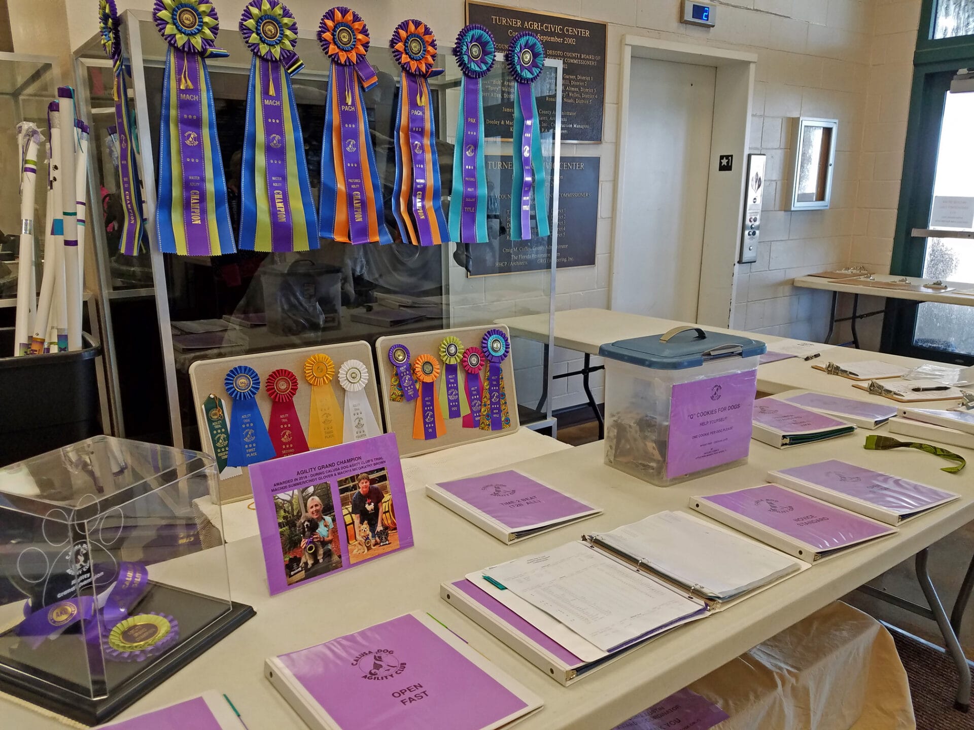 Agility score table with notebooks and ribbons beneath score monitor at Turner Agri-Civic Center, Arcadia FL