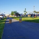 road block set up in front of agility trial area at easy up tents and dog crates along side of agility ring at East Idaho Fairgrounds-BlackfootID