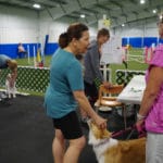 Tow women standing, one with border collie, chatting at Ann Arbor Dog Training Club, Ann Arbor MI