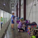 2 women in crating aisle area with dog kennels Soccer World, Rochester MN