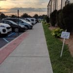 Parked cars in front of sidewalk and building at Silver Street Park, New Albany IN
