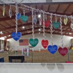 Metal heart tags engraved with names and dates in memorial of passed dogs at South St. Louis County Fairgrounds, Dirt Floor Arena, Proctor MN
