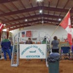 Wide view of Arrowhead Dog Agility Association's banner with flags on each side at South St. Louis County Fairgrounds, Dirt Floor Arena, Proctor MN