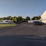 RV and cars parked in asphalt lot near building Pawsitive Partners, Indianapolis IN