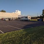 RV and cars parked in asphalt lot next to building Pawsitive Partners, Indianapolis IN