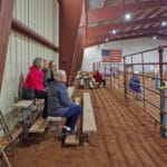 Trial attendees watch the trial ring while sitting on risers at South St. Louis County Fairgrounds, Dirt Floor Arena, Proctor MN