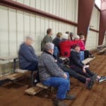 Happy trial attendees point, discuss and watch the trial from ringside risers at South St. Louis County Fairgrounds, Dirt Floor Arena, Proctor MN