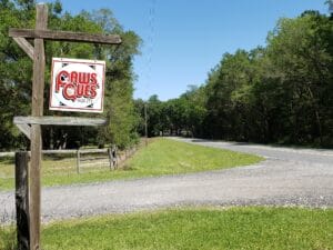 paw's & que's sign by road entrance