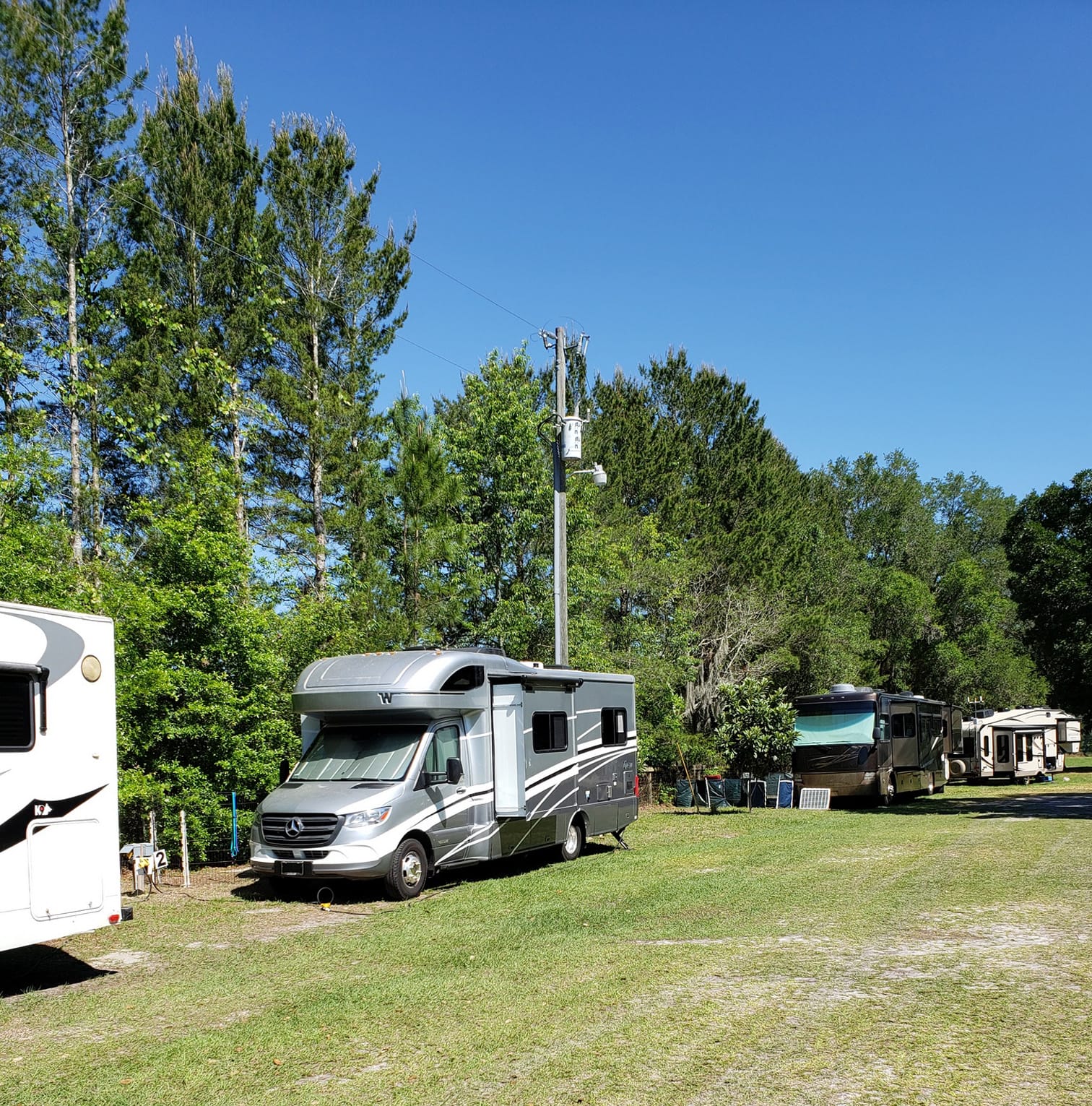 rv camping with electric hookups along fence, paw's n que's, williston fl